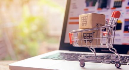 Shopping online concept - Parcel or Paper cartons with a shopping cart logo in a trolley on a laptop keyboard. Shopping service on The online web. offers home delivery.