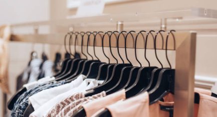 Dresses hanged on a rack in a clothing store.